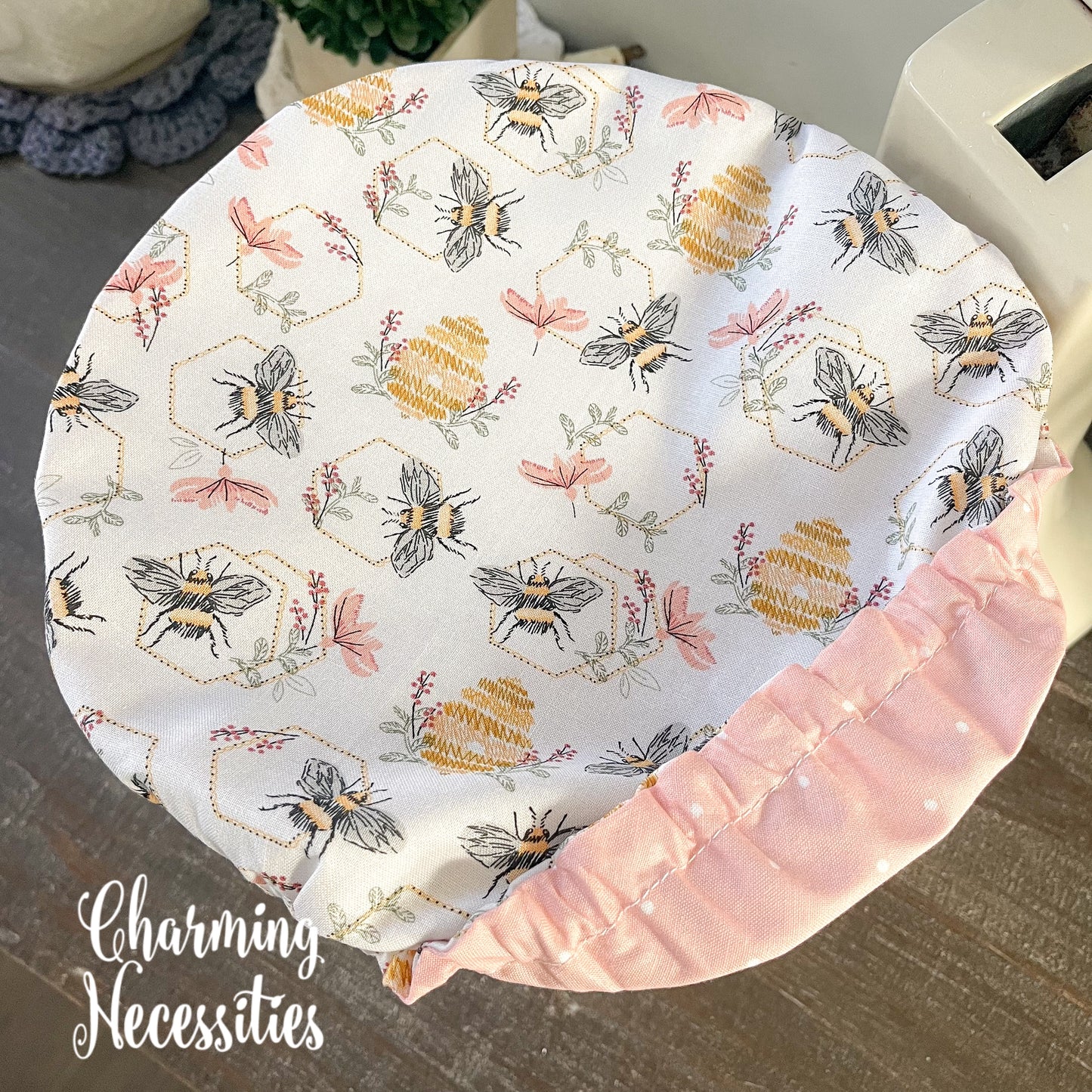 Cotton bowl cover featuring bees and honeycomb patterns, branded 'Charming Necessities'.