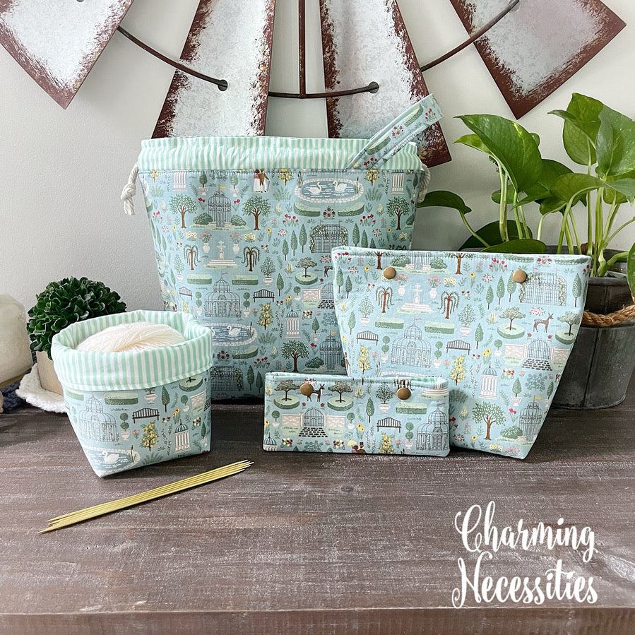 Set of regency themed fabric project bags with nature-themed design on a wooden surface, featuring the brand 'Charming Necessities'.