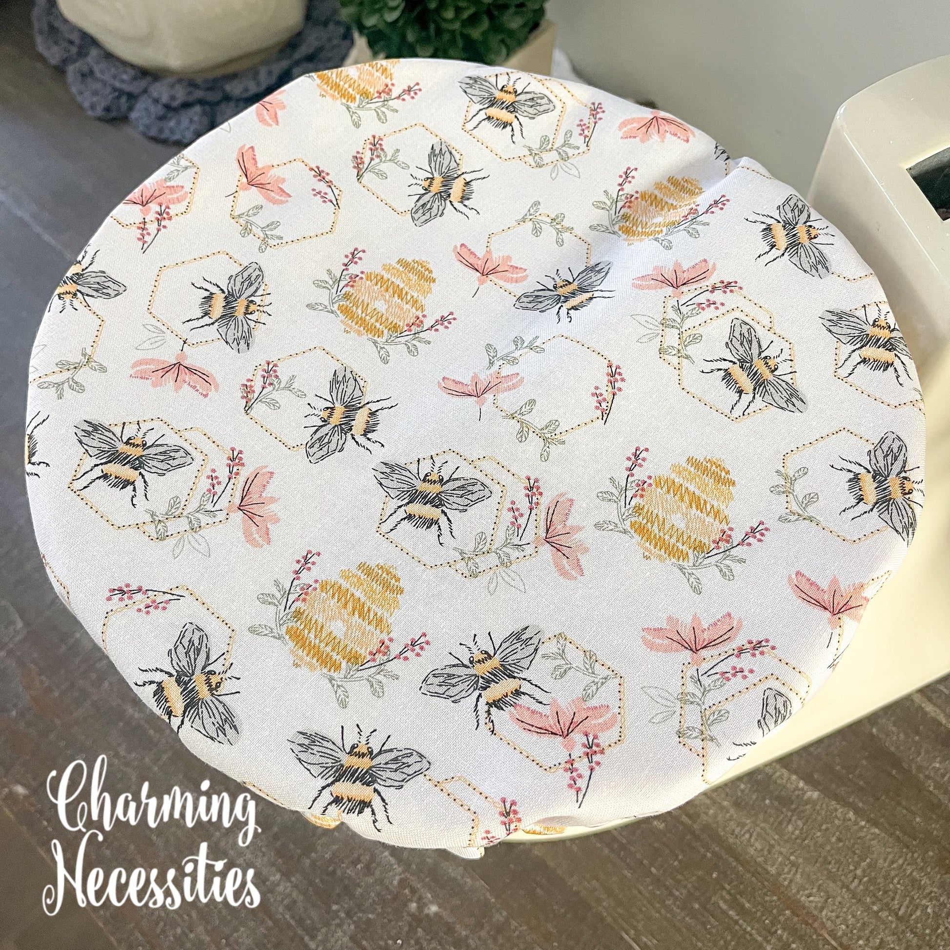 Bowl cover with bee and honeycomb pattern on a wooden table.